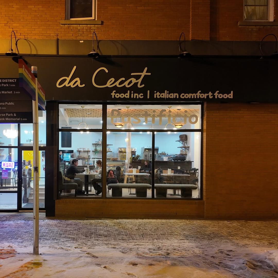 The da Cecot storefront on Whyte Avenue at night — warm lights, guests dining inside
